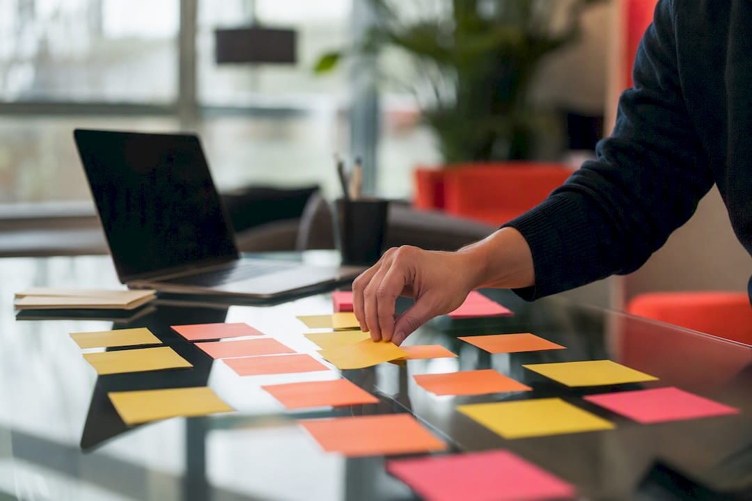 Hand adjusting sticky flags on project desk